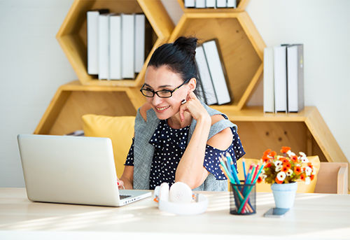 Woman looking at a laptop computer on a desk.